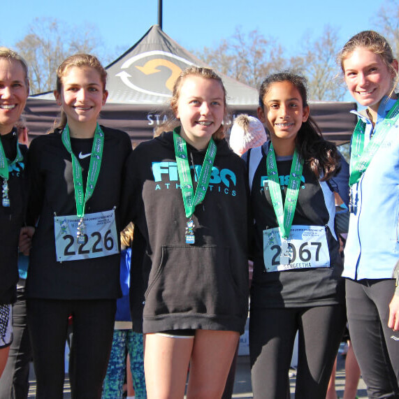 Caroll Ann taking photos with medal winning girl runners