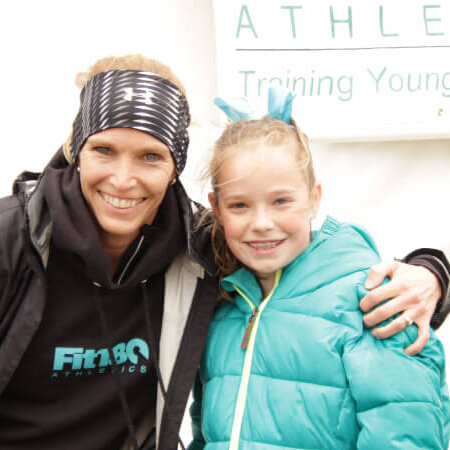 Coach Lisa smiling wide with one of the girl athletes for Training Young Champions