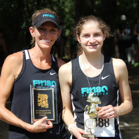 Coach Lisa taking photo with one of the first place winners of the race